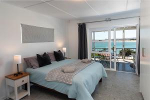 a bedroom with a bed with a view of the ocean at 'Seaside Cottage', Sleeps 4 with a 3 minute walk from the beach! in Cape Town