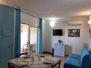 a living room with a table and a blue couch at Il Giardino di Viola in Porto Ottiolu
