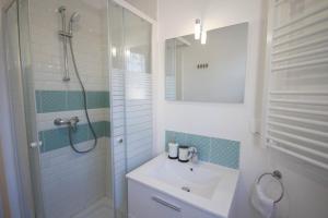 a white bathroom with a sink and a shower at Lille Centre - Nice and functional ap. 2bdrm in Lille