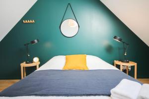 a bedroom with a large bed with a green wall at Lille Centre - Nice and functional ap. 2bdrm in Lille