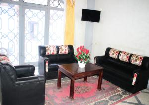 a living room with black leather furniture and a coffee table at HOTEL ERRACHIDIA in Er Rachidia