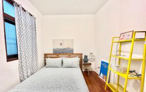 頭城的住宿－Sun Moment 鬆貓們民宿，一间卧室设有一张床和一个黄色架子