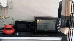 a microwave and a toaster oven on a counter at Samui Mekkala Resort in Choeng Mon Beach