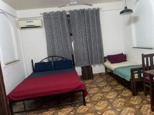 Zimmer mit 2 Betten, einem Tisch und Stühlen in der Unterkunft Pihuu hotel in Calangute