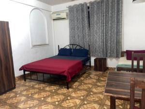 Zimmer mit einem Bett, einem Tisch und einem Fenster in der Unterkunft Pihuu hotel in Calangute