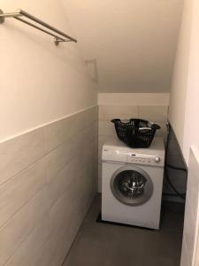 - Lavadora y secadora en una habitación pequeña en Ferienwohnung mit Blick auf den Feldberg, en Weilmünster