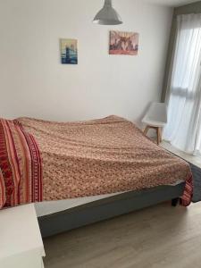 Un dormitorio con una cama con una manta. en Ferienwohnung mit Blick auf den Feldberg, en Weilmünster
