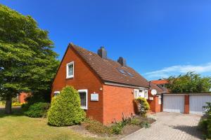 a red brick house with a garage at Ferienhaus Dohlennest in Carolinensiel