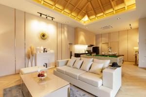 Nue Hatyai Pool Villa 147 في سونغكلا: غرفة معيشة مع أريكة وطاولة بلياردو
