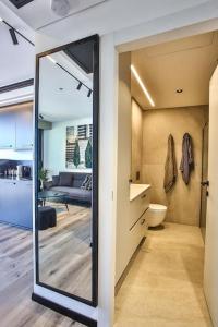Stunning 1BR Beach Apartment في تل أبيب: غرفة معيشة مع باب زجاجي كبير يؤدي إلى مطبخ