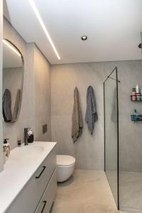 Stunning 1BR Beach Apartment في تل أبيب: حمام مع دش ومرحاض ومغسلة