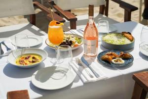 Stunning 1BR Beach Apartment في تل أبيب: طاولة بيضاء مع أطباق من الطعام والشراب