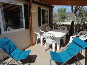 a deck with a table and chairs on it at 2 Mobil home chez Alain in Cadenet