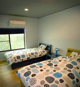 um quarto com 2 camas e uma janela em Ramjet Kisami Beach House Shimoda - Enjoy Spring Cherry Blossom, Beaches and BBQ! em Shimoda