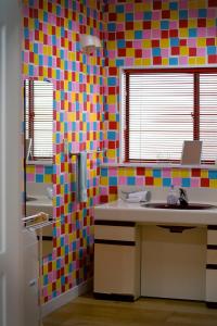 a bathroom with colorful tiles on the wall at Ramjet Kisami Beach House Shimoda - Enjoy Spring Cherry Blossom, Beaches and BBQ! in Shimoda