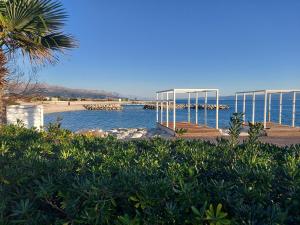 a view of a beach with a pier and the water at Apartman Zelic Split in Split