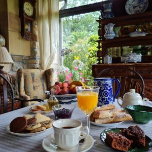 - une table avec des aliments pour le petit-déjeuner et un verre de jus d'orange dans l'établissement Posada Los Lienzos, à Vargas