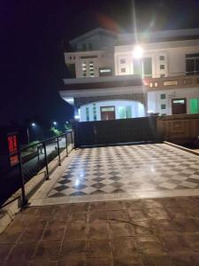 un pavimento a scacchi di fronte a un edificio di notte di AK House Guest House a Islamabad