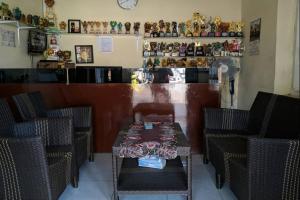 une salle à manger avec une table, des chaises et un comptoir dans l'établissement OYO 93571 Wisma Air Mancur Homestay, à Malang