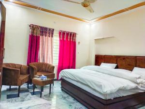 1 dormitorio con 1 cama y 1 silla en AK House Guest House en Islamabad