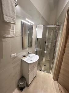 baño blanco con ducha y lavamanos en Buongiorno & Benvenuti en Trani
