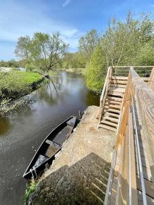 ein Boot auf einem Fluss neben einer Brücke in der Unterkunft Maison avec vue imprenable sur la Brière in Saint-Joachim