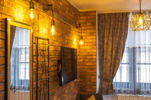 a room with a brick wall with a television and windows at B&B Plitvice Queen in Plitvička Jezera