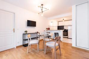 eine Küche und ein Esszimmer mit einem Tisch und Stühlen in der Unterkunft Euratechnologies - Bright apartment with parking in Lille