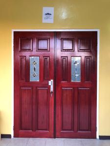 a pair of red doors in a building at Logerthine Studio Suriname in Paramaribo