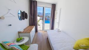 a room with a bed and a table and a balcony at Holiday Home Noa in Mostar