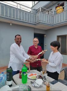 a group of people standing around a table at Three Brothers Apartment and Hotel in Kathmandu