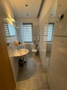 een badkamer met een toilet, een wastafel en een douche bij ESA Home in Warschau