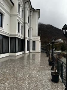 un edificio con un marciapiede bagnato dalla pioggia accanto a una strada di 4 Stinët a Valbona