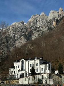 una casa blanca frente a una montaña en 4 Stinët, en Valbonë