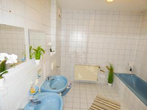 La salle de bains est pourvue d'un lavabo bleu et d'une baignoire. dans l'établissement SUNNYHOME Monteurwohnungen und Apartments in Schwandorf, à Schwandorf in Bayern