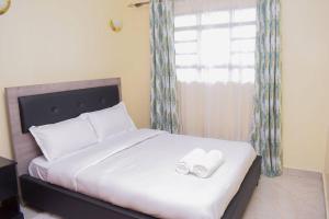 ein Schlafzimmer mit einem Bett mit zwei Handtüchern darauf in der Unterkunft Marvel Homes in Meru
