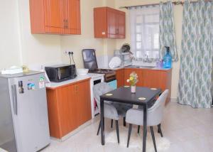a small kitchen with a table and a refrigerator at Marvel Homes in Meru