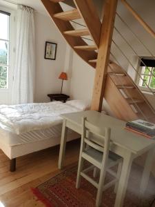 ein Schlafzimmer mit einem Bett, einem Tisch und einer Treppe in der Unterkunft Le Clos- Le Pavillon in Lombard