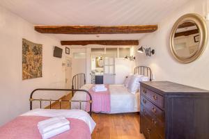 a bedroom with two beds and a mirror at Hôtel Restaurant Les Remparts in Venasque