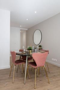 een eetkamer met een tafel met roze stoelen en een spiegel bij Hypercentre -Apartment in pedestrian zone in Lille
