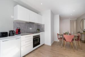 een keuken met witte kasten en een tafel met stoelen bij Hypercentre -Apartment in pedestrian zone in Lille +14 foto's