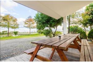 una mesa de picnic de madera en el porche de una casa en 建築師湧泉泡湯會館, en Dongshan