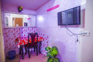 Habitación con mesa y TV en la pared. en Hotel Victoria Inn (Nazimuddin Road), en Dhaka