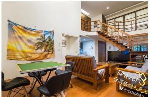 a living room with a ping pong table and a staircase at 建築師湧泉泡湯會館 in Dongshan