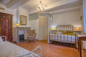 a bedroom with a bed and a fireplace and a chandelier at Hôtel Restaurant Les Remparts in Venasque