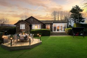 ein Haus mit einem Tisch und Stühlen im Hof in der Unterkunft Sunset Cottage in Sandwich