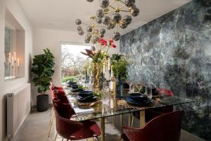 une salle à manger avec une table en verre et des chaises rouges dans l'établissement Sunset Cottage, à Sandwich