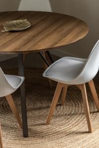 una mesa de madera y 2 sillas blancas junto a una mesa en Ķīpsala apartments with free parking, en Riga