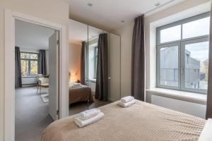 a bedroom with two beds and a mirror at Ķīpsala apartments with free parking in Riga