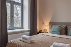 a bedroom with a bed with two towels on it at Ķīpsala apartments with free parking in Riga